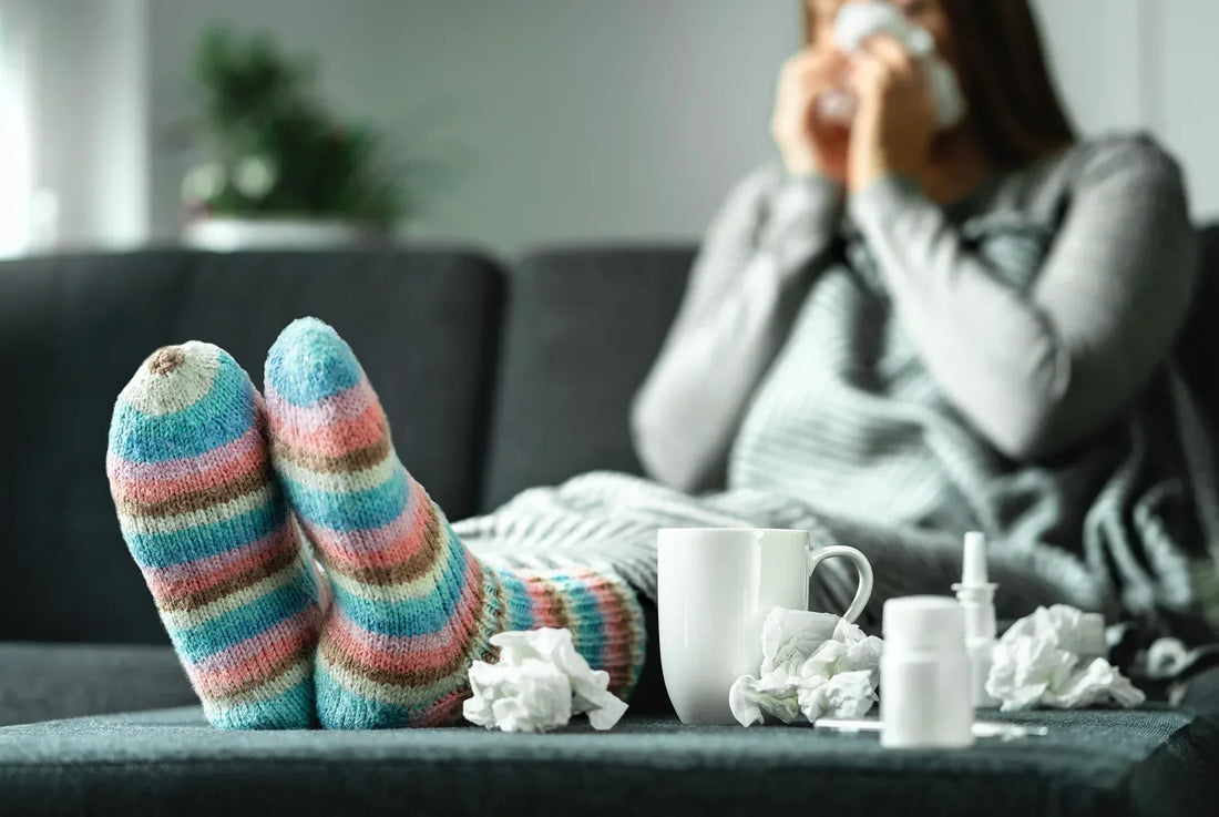 Wollsocken - Frau sitzt krank auf Sofa