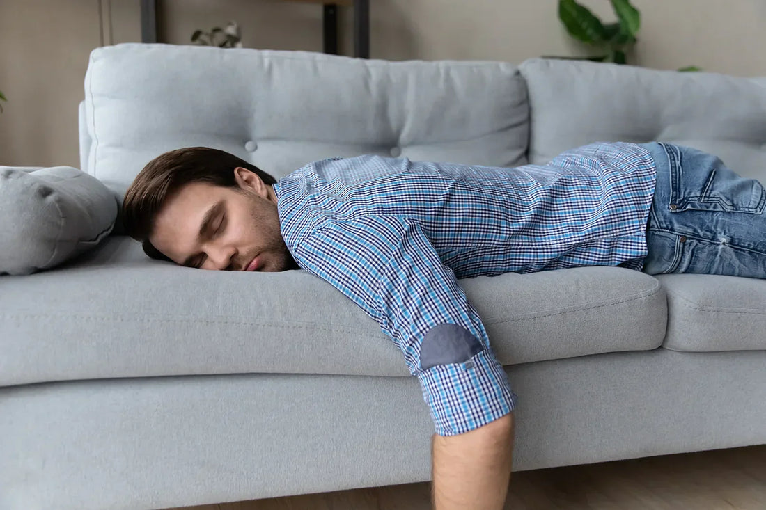 Mann liegt müde auf dem Sofa
